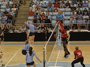 Senior outside hitter Madison Laufenberg (14) spikes the ball towards her NC State opponents on Wednesday, Sept. 26 in Carmichael Arena.
