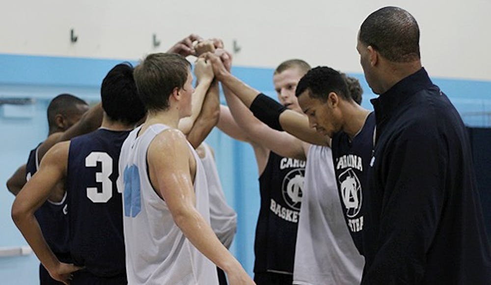 	The North Carolina junior varsity basketball team huddles in front of assistant coach Hubert Davis.