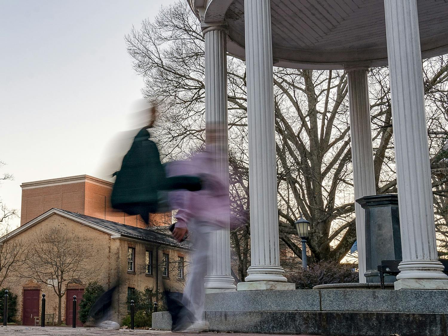 Students walk by the Old Well on Monday, Feb. 6, 2023.