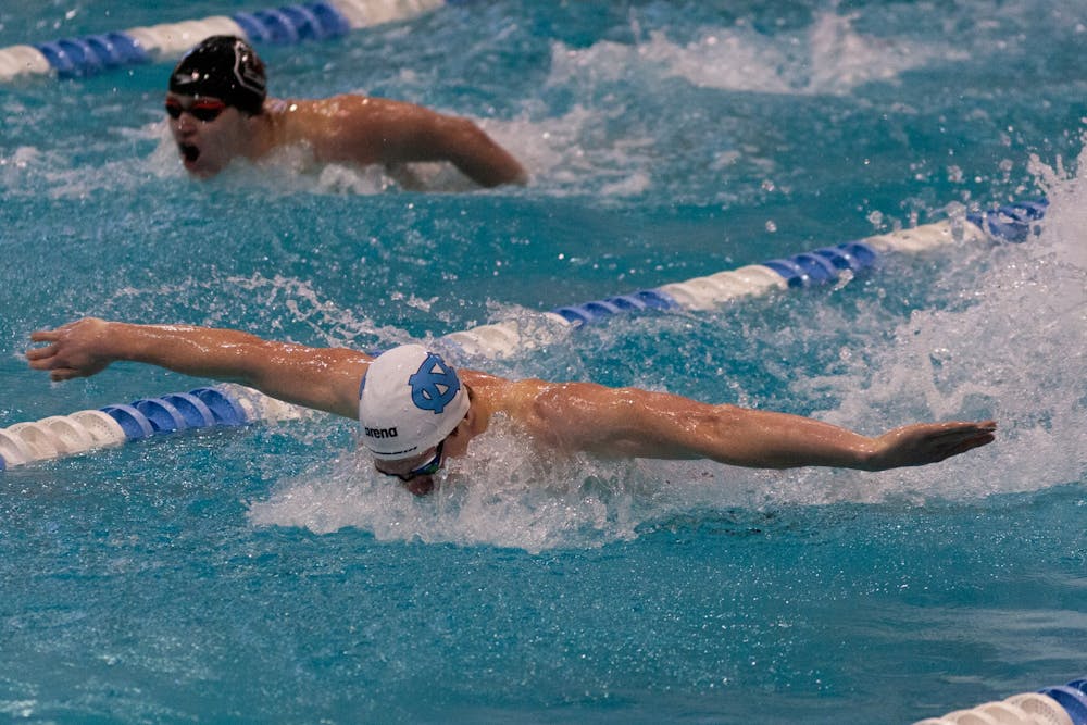<p>UNC junior fly Boyd Poelke outpaces a South Carolina swimmer in butterfly during the UNC swim and dive meet against South Carolina at Koury Natatorium on Saturday, Nov. 5, 2022. UNC beat South Carolina 179-115 on the men’s side and 178-122 on the women’s side.</p>