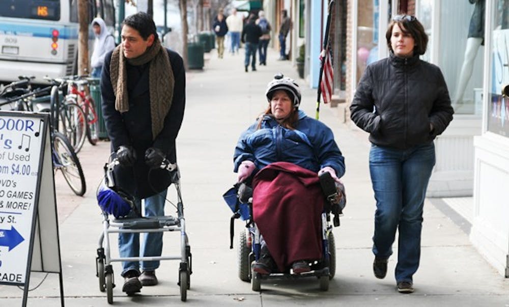 Chapel Hill Mayor Mark Kleinschmidt uses a walker on Franklin Street with wheelchair user Ellen Perry. DTH/Will Cooper