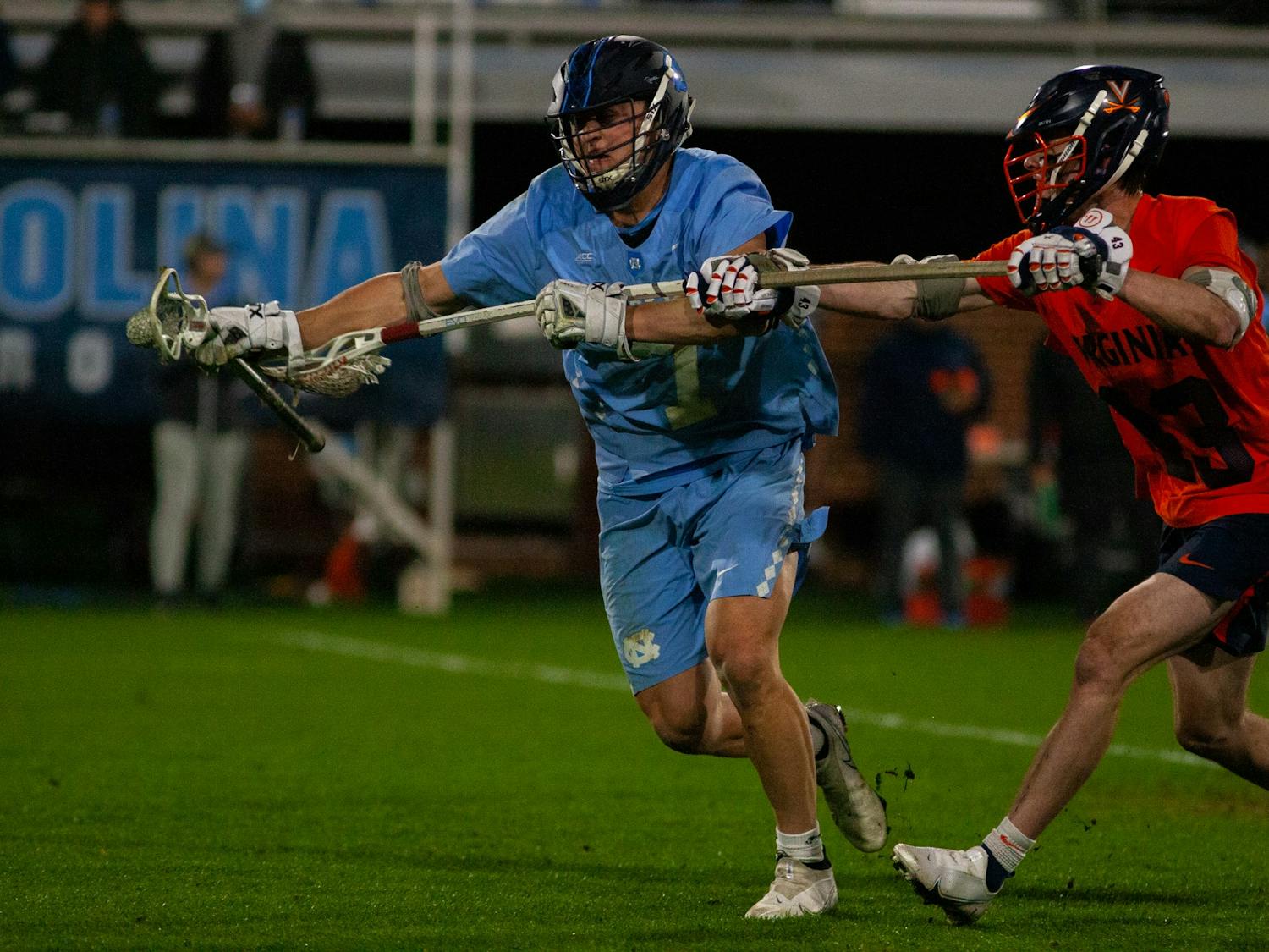 Senior midfielder Zac Tucci (7) protects the ball during the Tar Heels' 15-11 loss against UVA on Thursday, Feb. 11, 2022 on Dorrance Field in Chapel Hill, N.C. Tucci finished the night with 7 ground balls and two shots, one on goal.
