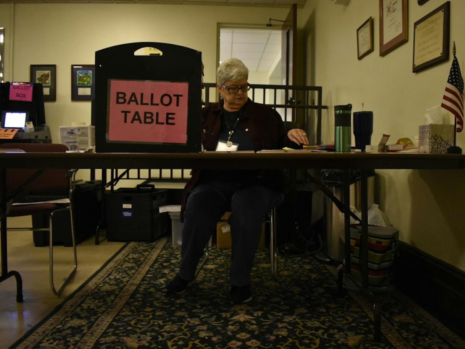 Connie Wilkins runs the ballot box table at The Chapel of the Cross church at 304 E. Franklin St. on Oct. 23, 2018. The Chapel of the Cross severs as an early voter location close to the University of North Carolina at Chapel Hill's campus. 