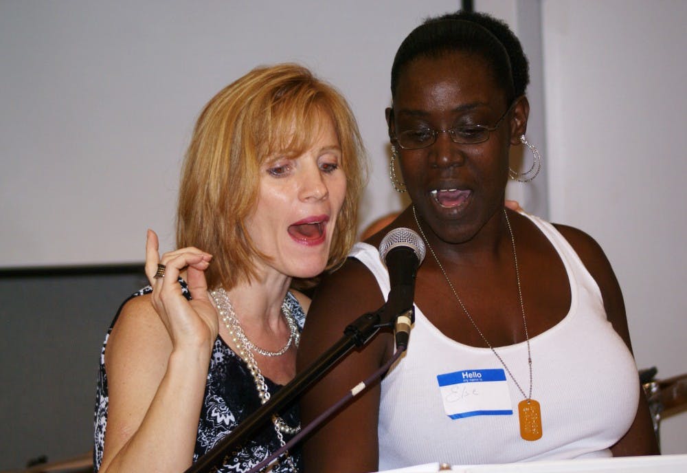 Stacy Carelop and Elsie Woods sing "I Will Survive" for the clients at Freedom House on Thursday night.
