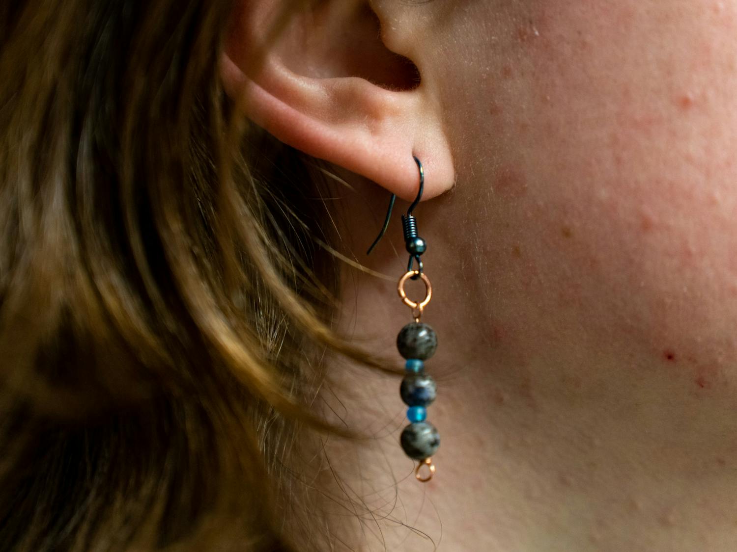 DTH Photo Illustration. A UNC student wears an earring in his ear.