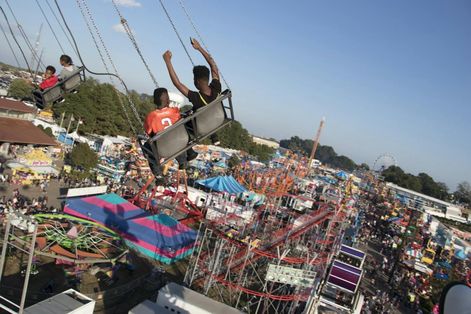 Two children ride the swing ride, overlooking the entire midway.