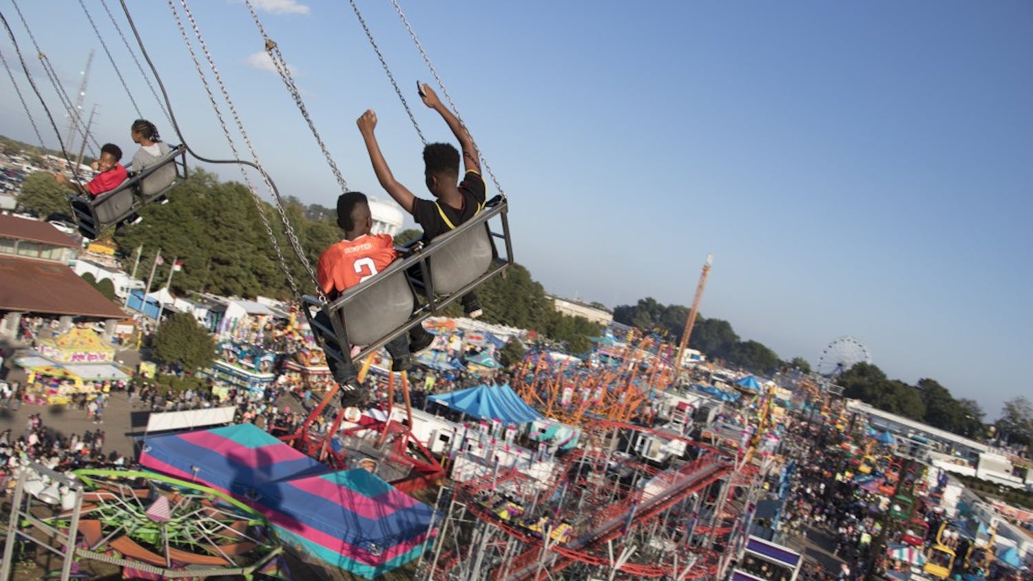 Two children ride the swing ride, overlooking the entire midway.