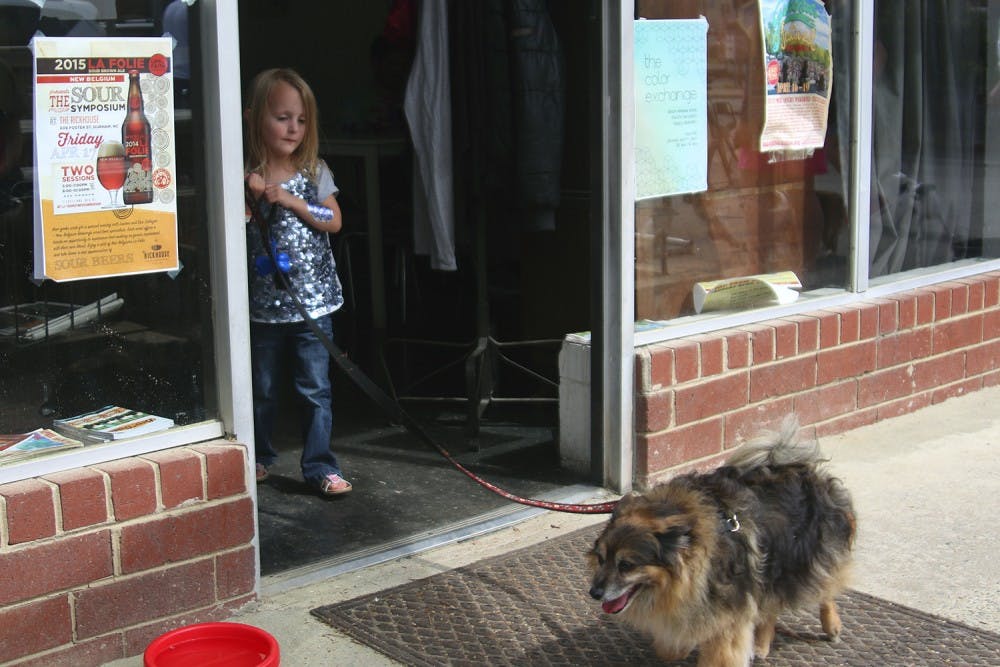 Zoey Atkins walks her dog Guinness around the outside of BeerStudy before the start of the dog parade on Sunday afternoon. 