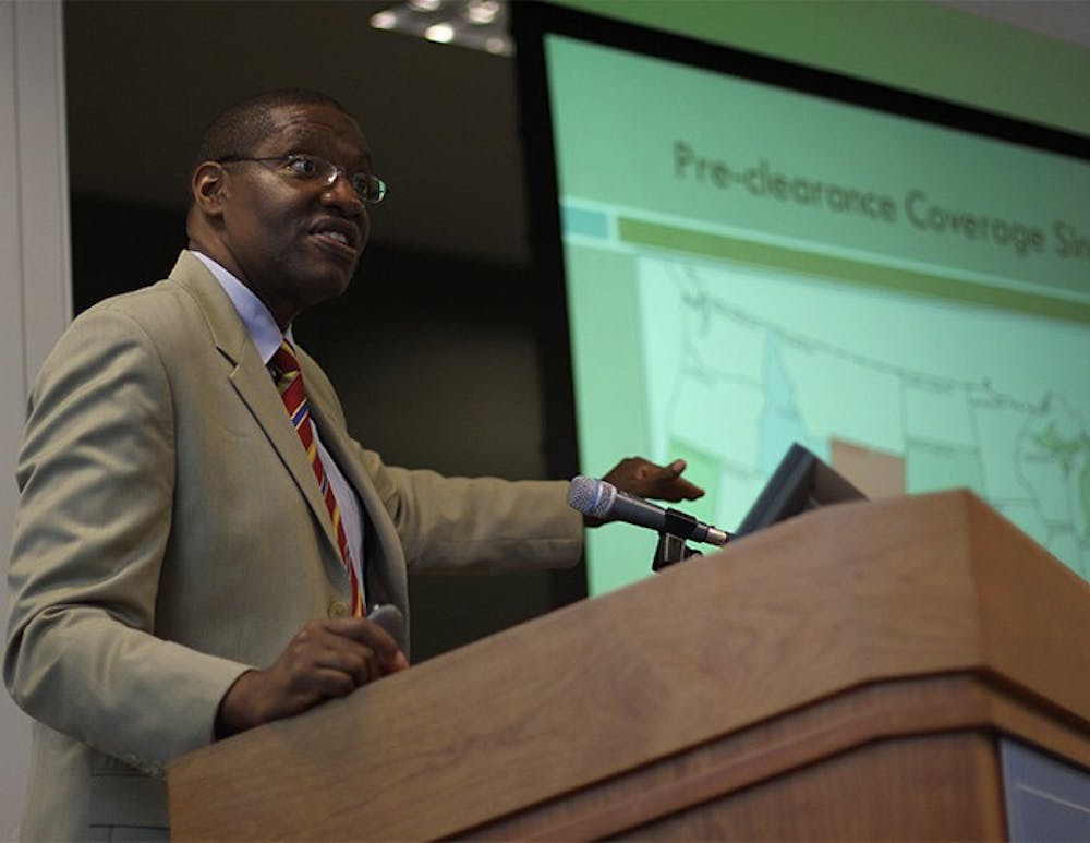 Kareem Crayton, Associate Professor of Law, introduces the Voting Rights, Racial Justice and Moral Mondays: Examining Civil Rights in the 21st Century symposium in Wilson Library on Thursday. 
