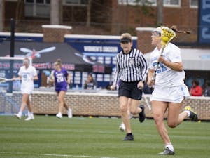 UNC first-year midfielder Marissa White (21) runs up the field during the women's lacrosse game against JMU on Saturday, Feb. 11, 2023, at Dorrance Field. UNC won 14-9.