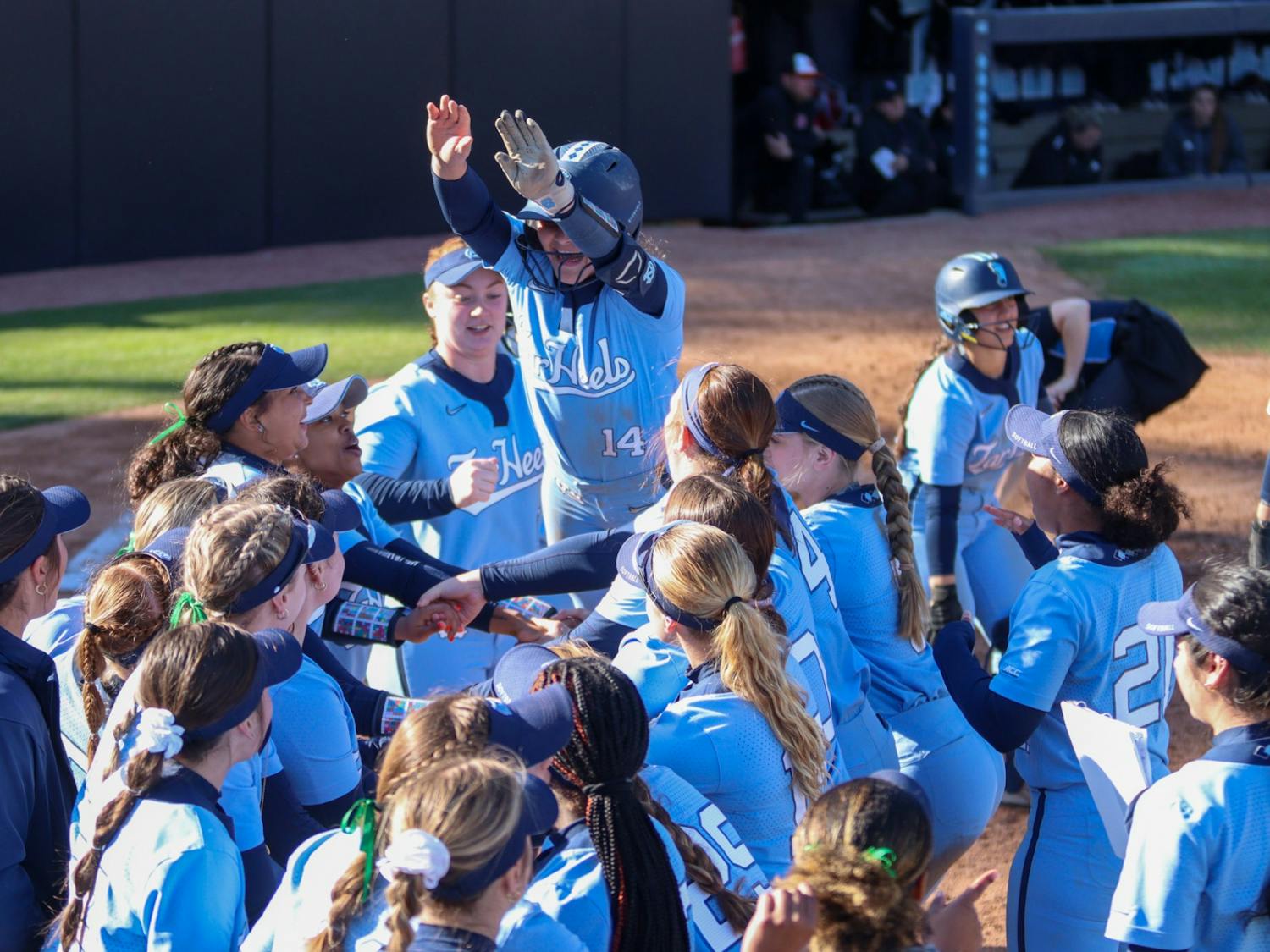 The team celebrates a home run from utility player Kianna Jones (44). UNC beat NC State 16-4 at home on Sunday, March 27, 2022.