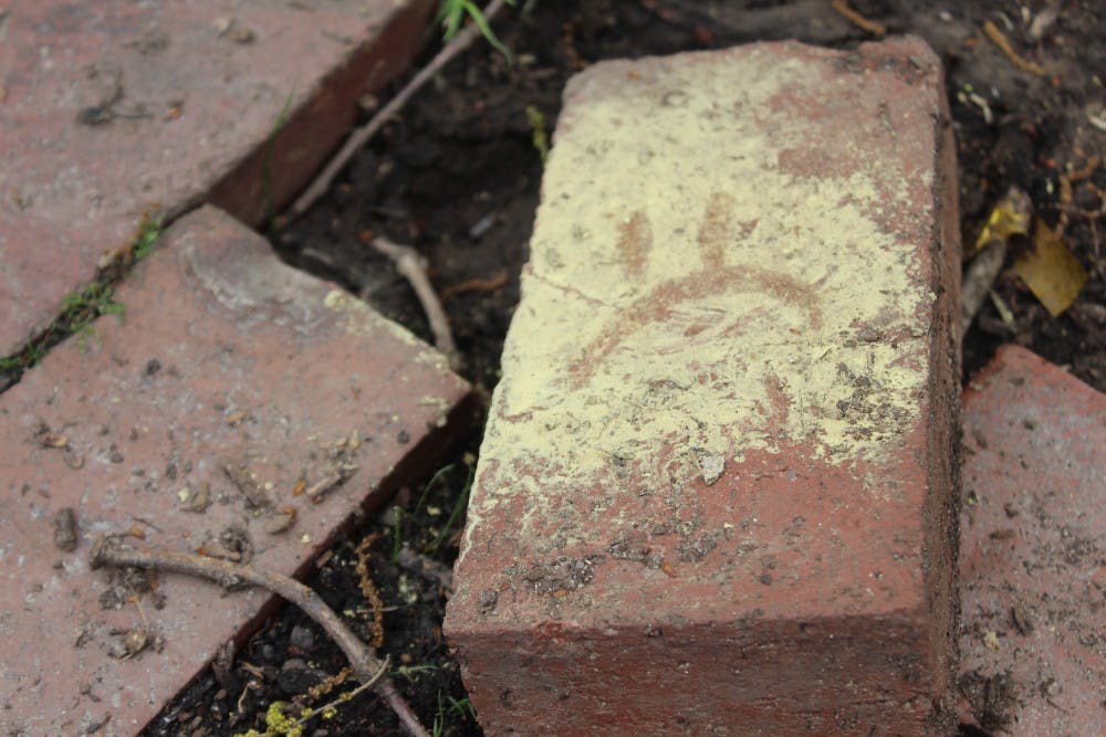 A brick covered with pollen outside of South building on Sunday, April 4, 2019.