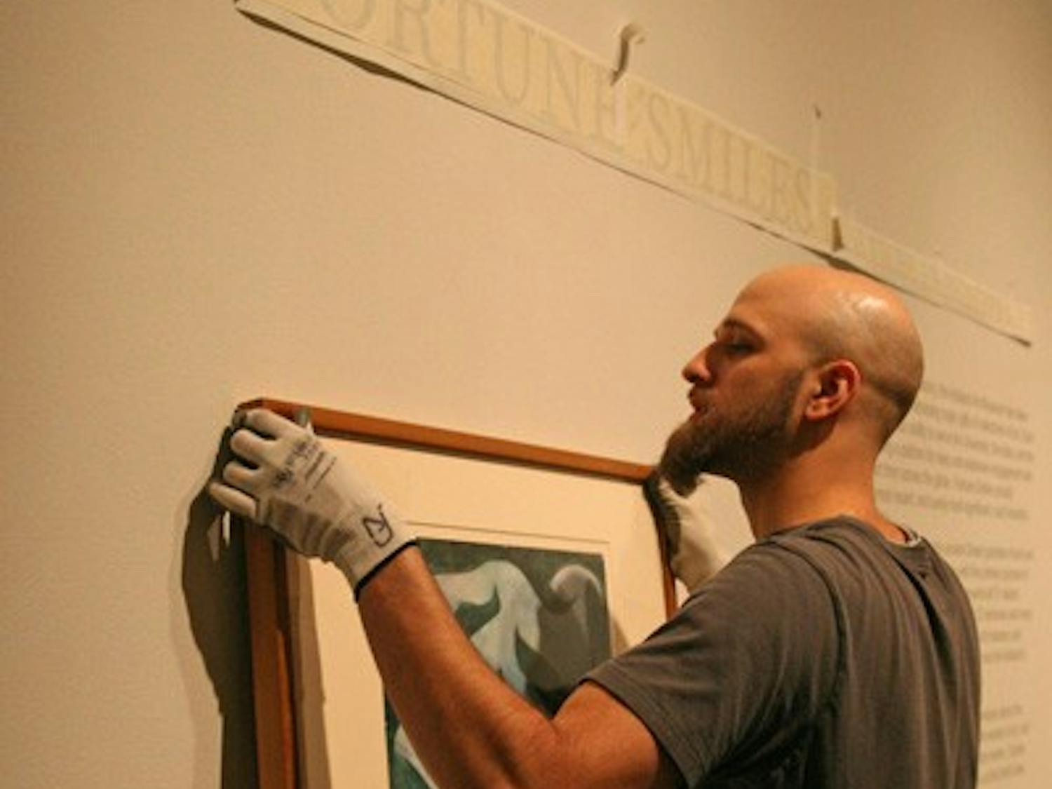 Ackland Art Museum preparator Andrew Nagy hangs a painting for a new exhibit. DTH/Becca Brenner