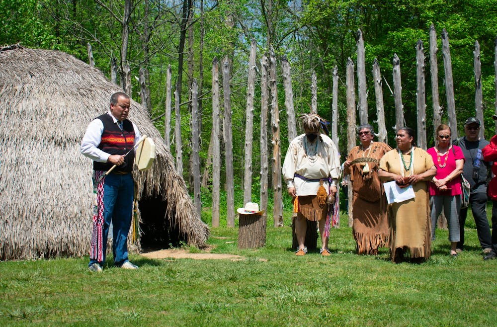 Jason Evans, a member of the Haliwa Saponi Tribe, performs music as Occaneechi tribal members listen at the Occaneechi Replica Village rededication event on Saturday, April 23, 2022.