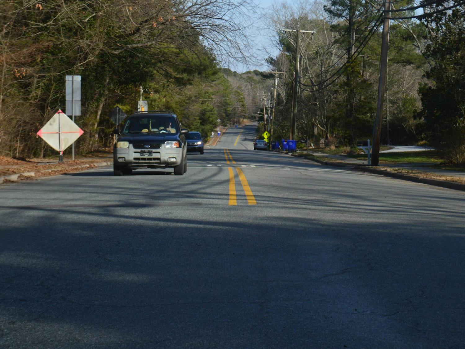 Cars drive down the busy Ephesus Church Road in Chapel Hill, NC on Tuesday, Feb. 15, 2022. The Town of Chapel Hill has proposed bike lanes that would result in narrower vehicle lanes and the prohibition of roadside parking.