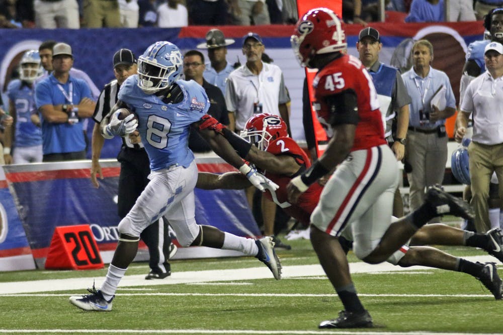 <p>UNC running back T.J. Logan (8) sheds a tackle from Georgia defensive back Maurice Smith (2) en route to his first touch down of the day. The Tar Heels fell to the Bulldogs 33-24 on Saturday in Atlanta.</p>