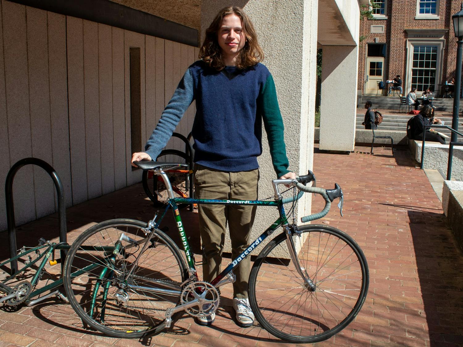 First-year environmental science major Tasso Hartzog poses with his bike outside of Greenlaw Hall. Tasso was injured after being hit by a car while riding his bike but still relies on his bike for local transportation.