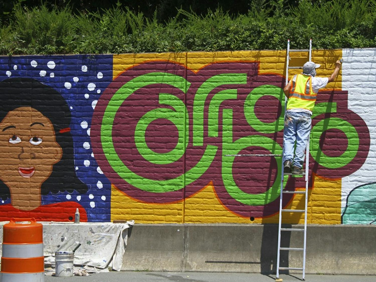 UNC graduate Michael Brown paints a mural for the City of Carrboro off of Jones Ferry Road on Tuesday afternoon.