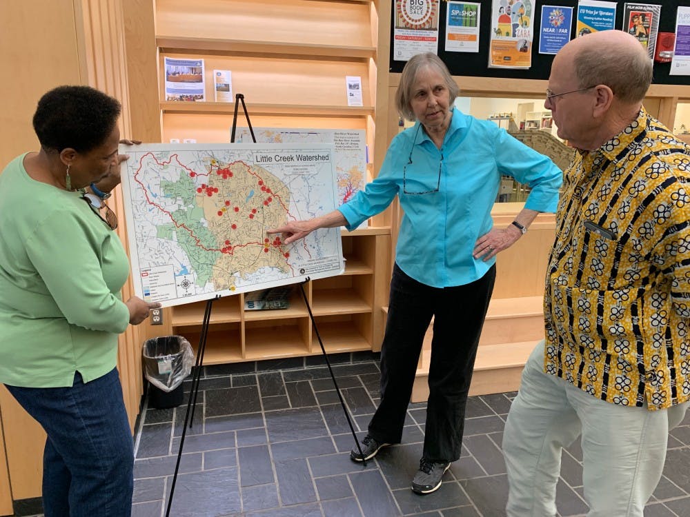 <p>CHALT members Linda Brown (left) Julie McClintock (center) and Charles Humble (right) discuss watersheds and their environmental impacts in the Chapel Hill Public Library on Thursday, April 4th, 2019.</p>