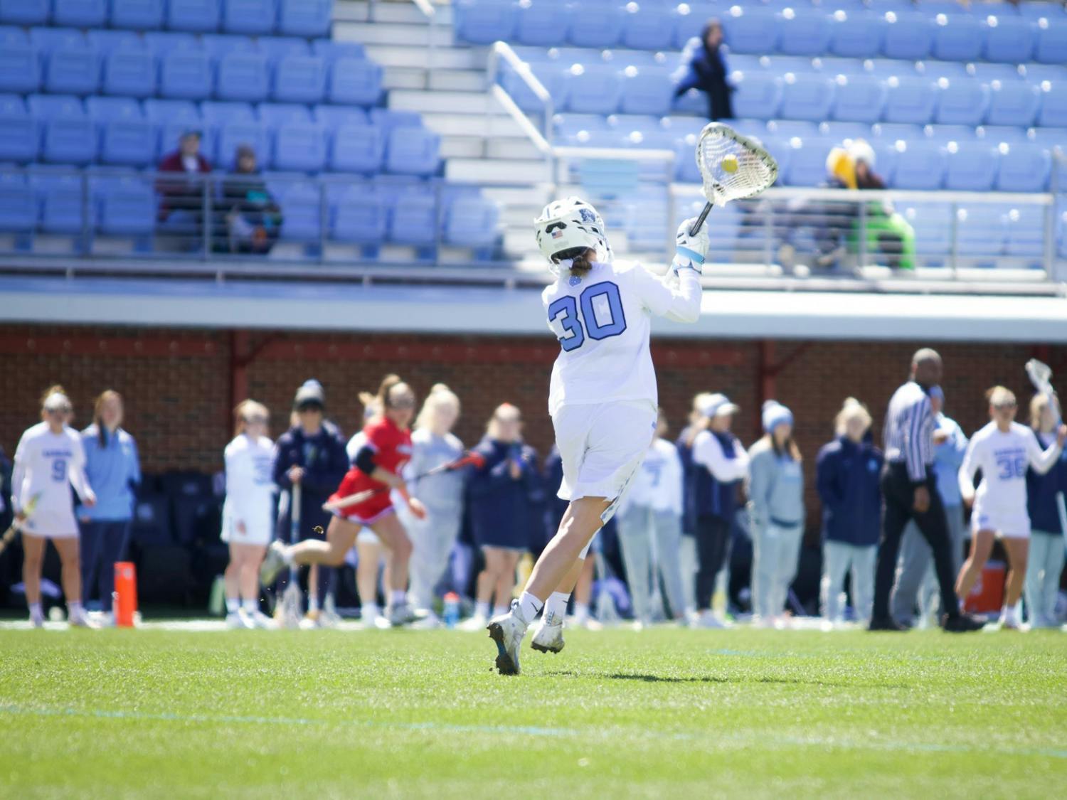 Goalkeeper Taylor Moreno (30) passes the ball back to a teammate after preventing Louisville from scoring at a home game. The Heels won 21-8 on Sunday, March 13, 2022.