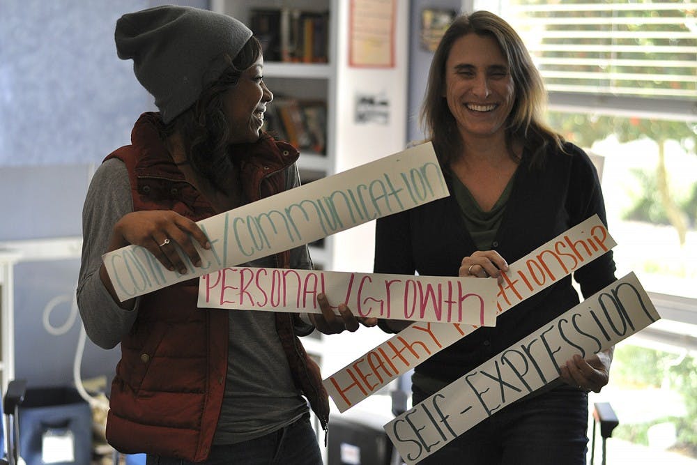 The YMCA Boomerang Program provides a place for suspended students to receive mentoring and complete school work. Program Manager Shayne Moore (left) and Program Director Tami Pfeifer hold cards with words used as "themes of the day."
