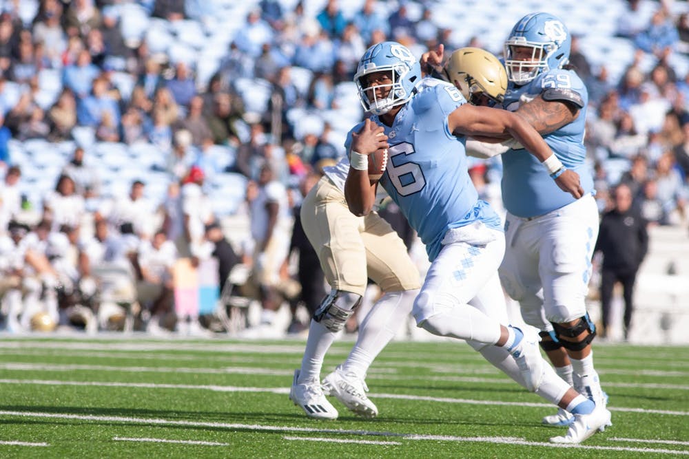UNC sophomore quarterback Jacolby Criswell (6) rushes past Wofford's defense with a block from UNC graduate student offensive lineman Quiron Johnson (69) on Nov. 20 at Kenan Stadium. UNC beat Wofford 34-14.