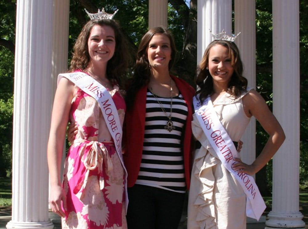 Miss NC Pageant contestants in front of the Old Well. Summer Hennings (pink dress), Dominque Alston (beige dress), Maddisson Sheppard (no crown or sash)
