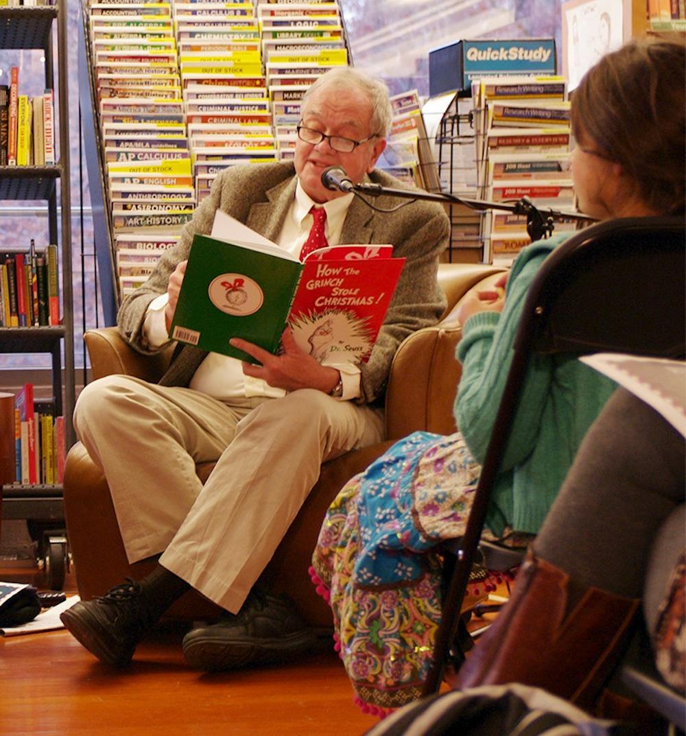UNC Student Stores employee George Morgan (left) and Professor Tom Stumpf (right) read "How the Grinch Stole Christmas" in Latin and English at Bull's Head Bookshop's annual reading. 