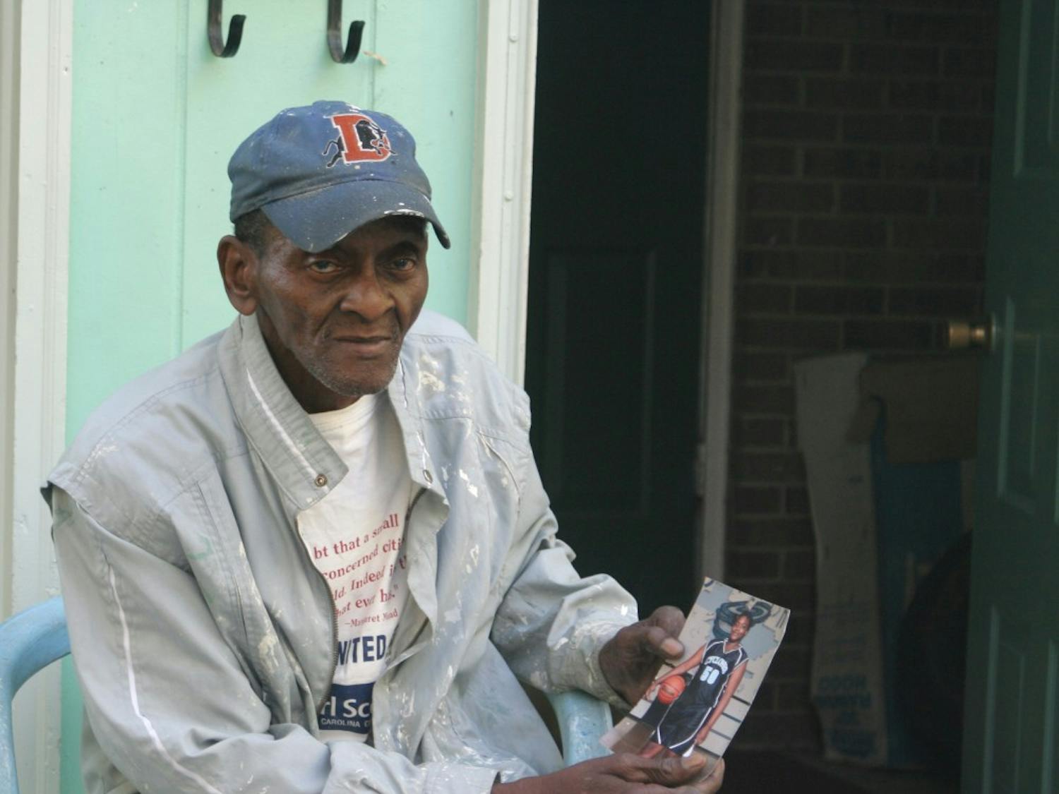 Walter Morrow (above) holds a photo of his 14-year-old daughter outside their home on Bynum Street.