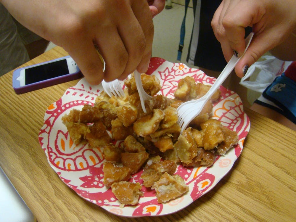 	<p>Students dig into the warm donut cake right out of the oven.</p>