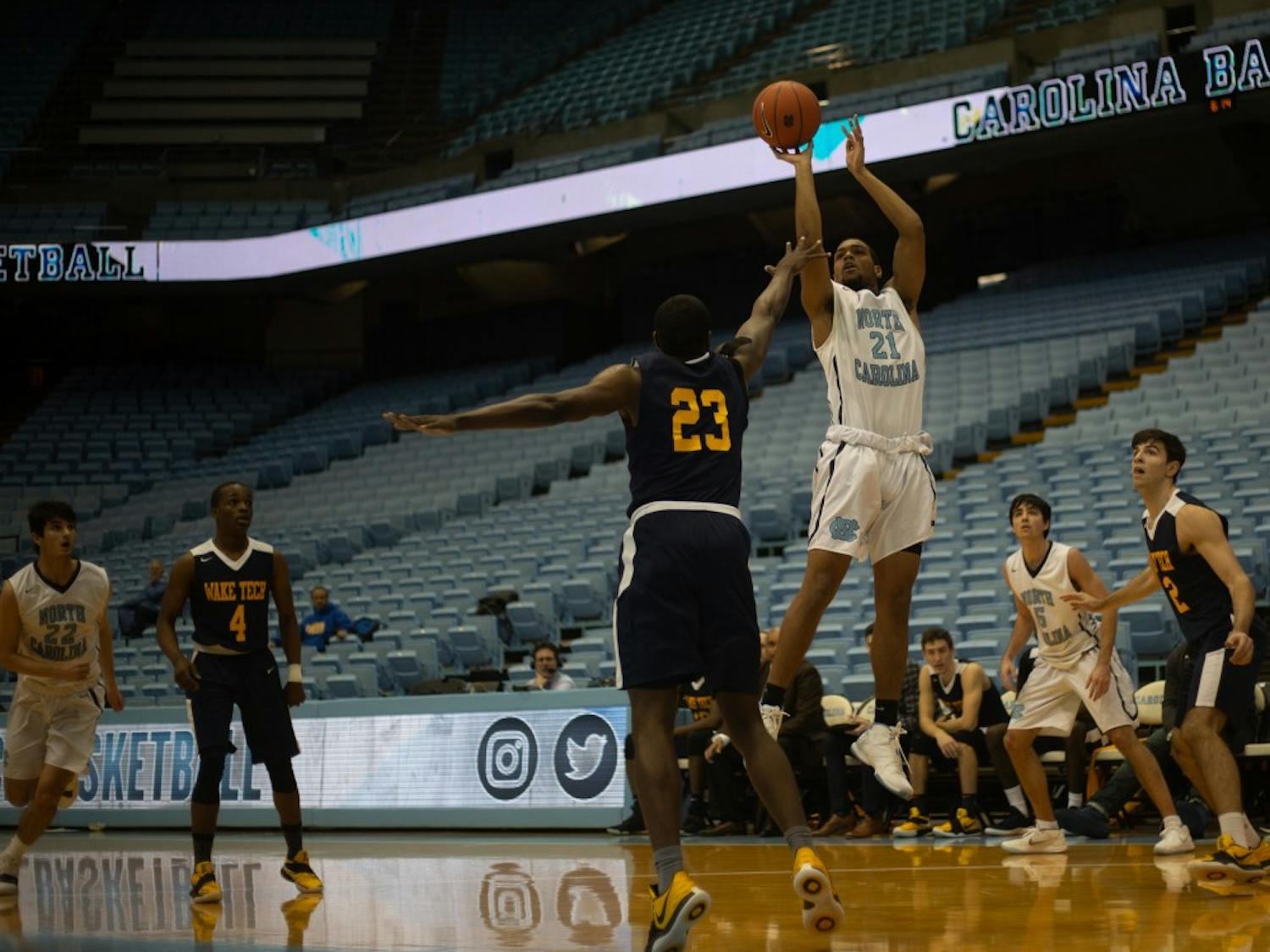 Michael Armstrong (23) attempts to block Nehemiah Stewart (21) from making a basket during a game against Wake Tech on January 15, 2019 at the Dean E. Smith Center. UNC JV won 80-64.