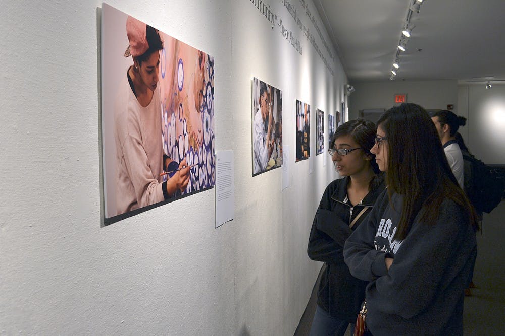 Sophomore biology majors Seher Khalid (Left), from High Point, and Noor Baloch, from Cary, display the gallery reception: Passion in Practice in the Union on Wednesday evening.