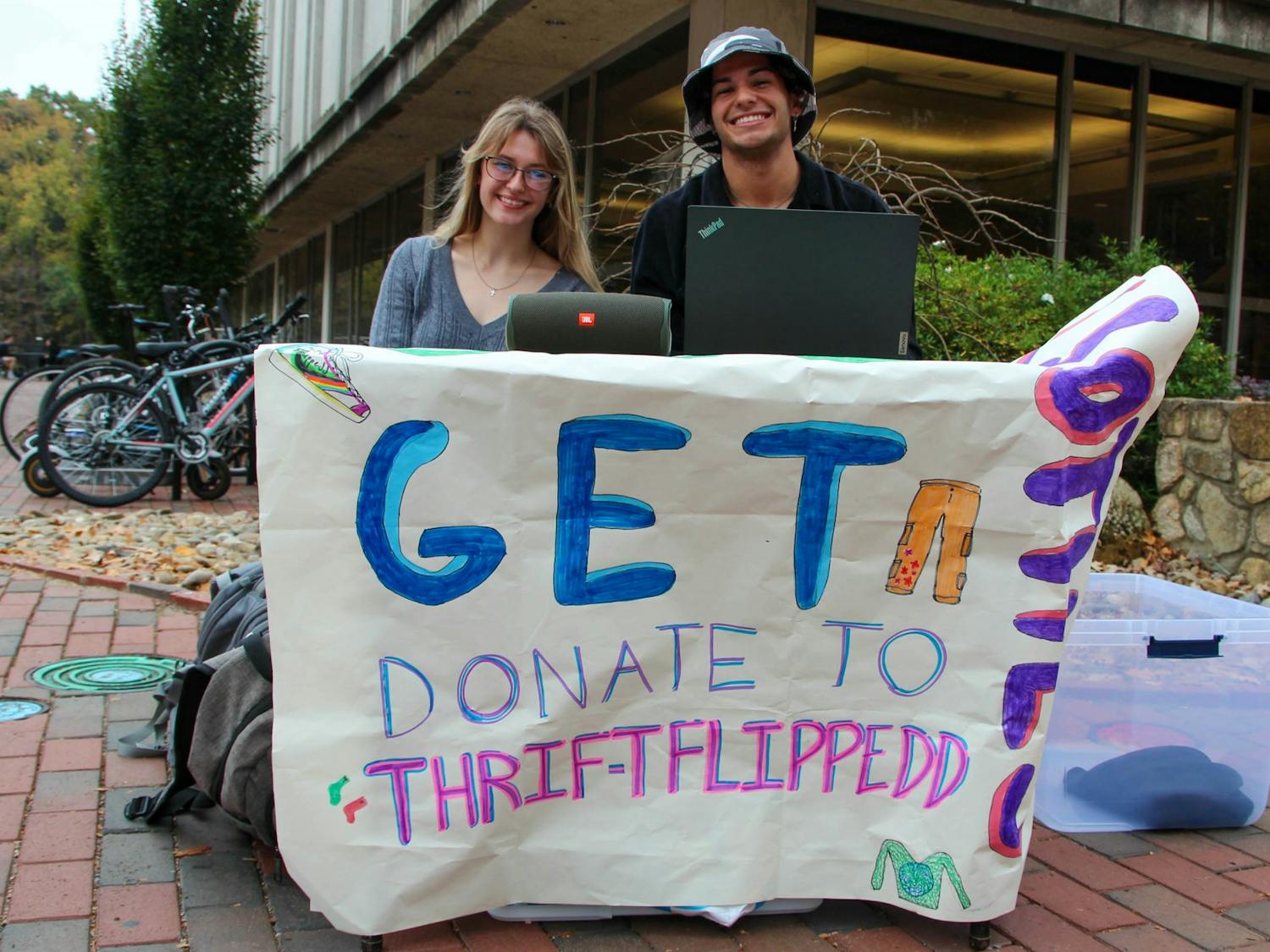 First-year Naomi Major and sophomore Redding Thomas pose for a portrait at the Pit on Oct. 26, 2022. Thrift Flippedd is a new thrift store on campus aiming to teach and practice sustainable fashion.