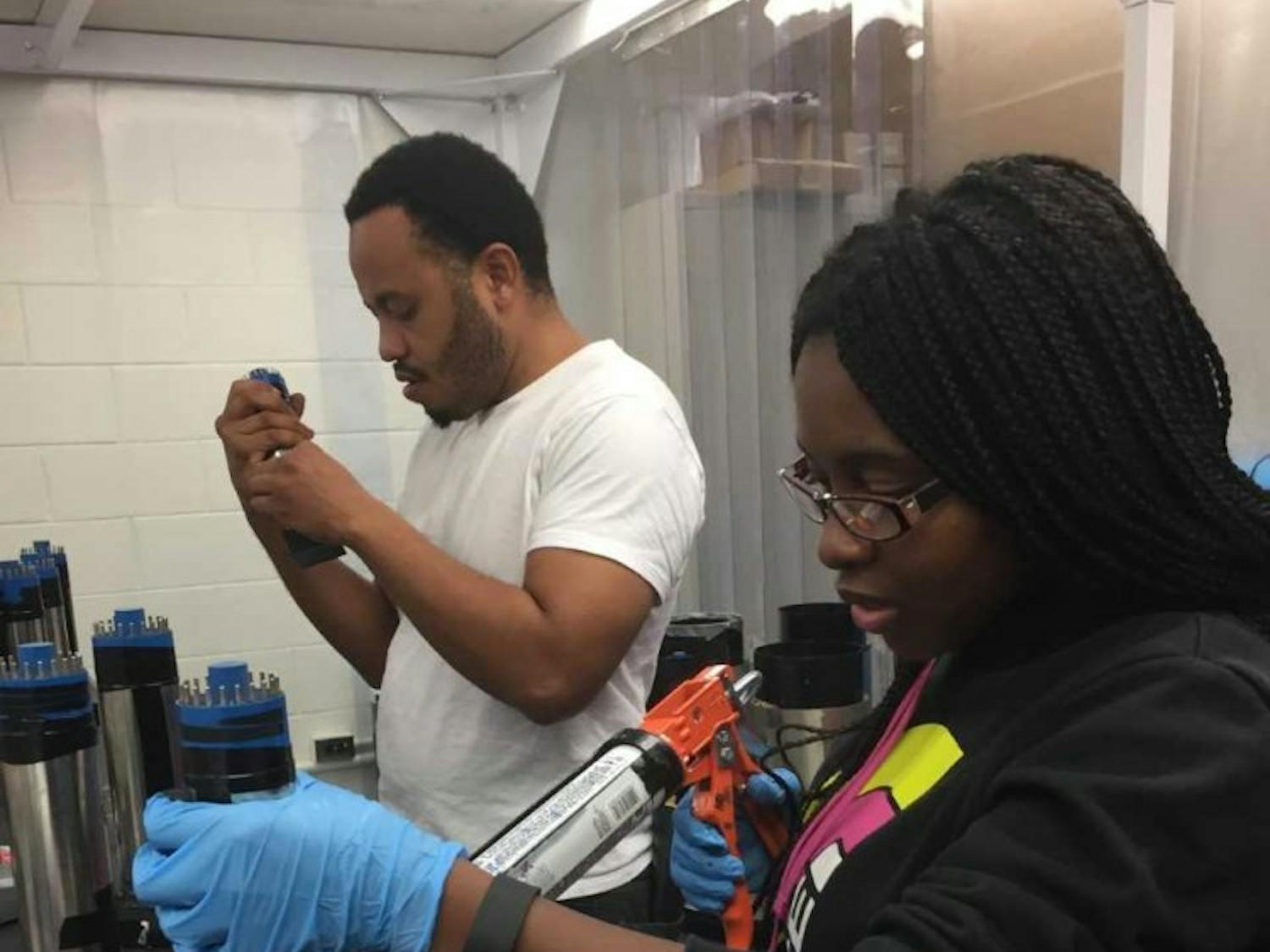 NCCU Students, Abasi Brown and Deandria Harper, working at TUNL Lab. Photo courtesy of Quiana Shepard.