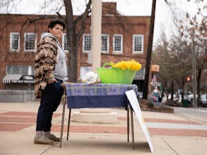 Rebecca Mills, 18, of Chapel Hill, waits to sell a daffodil at the Peace and Justice Plaza on Sunday, Feb. 16, 2020. Mills has sold flowers from her backyard to benefit charity for 14 years. "I feel like it's very important to help people with what you have. I have the opportunity to be able to cut all of these flowers in my backyard," she said. "I feel like it would be silly to not use that opportunity."