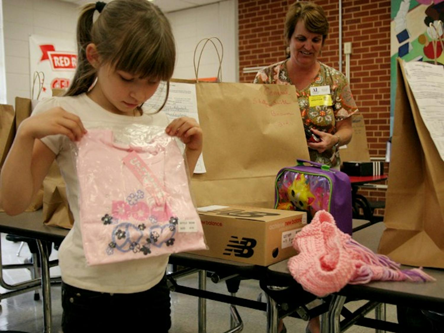 Shelly Smith,7, holds up a pink shirt she got from Operation School Bell, a program run by the Assistance League of the Triangle area.