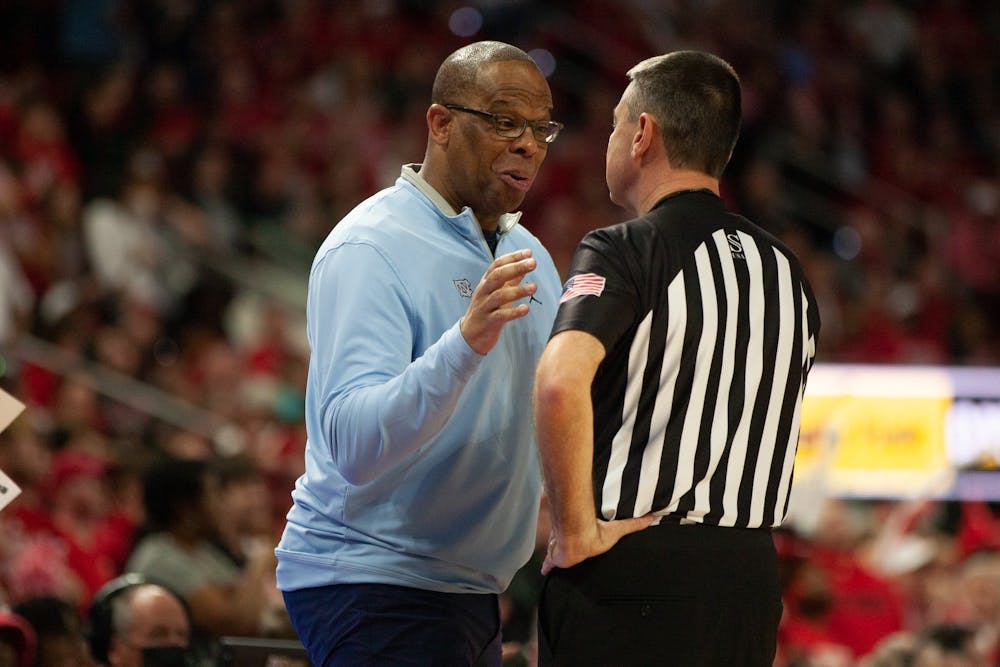 <p>UNC head coach Hubert Davis speaks with a referee at the men's basketball game against N.C. State on Feb. 19, 2023, at PNC Arena. N.C. State won 77-69.&nbsp;</p>