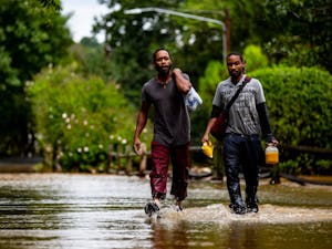 Kyrie and Michael Benton carry food and some of their waterlogged belongings through the grounds of Camelot Village apartments in Chapel Hill the morning of Sept. 17, 2018. Chapel Hill had been seemingly spared the worst of Hurricane Florence but Sunday night into Monday morning saw a downpour of heavy rain that caused flash flooding around the Triangle. Camelot Village has seen flooding in the past but never to this degree, according to Kyrie and other residents of many years. "I lost everything in this flood," Kyrie said. Just as quickly as it flooded, the water began to recede late the same morning and early in the afternoon.