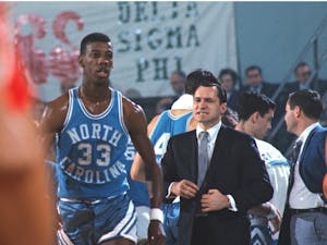 Former UNC guard Charlie Scott stands next to Dean Smith. Photo courtesy of UNC Department of Athletics.