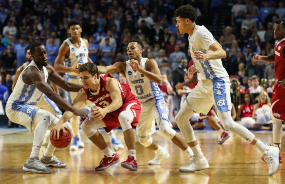 The North Carolina basketball team swarms Arkansas guard Dusty Hannahs (3) leading to a turnover in the second round of the NCAA Tournament in Greenville on Sunday.