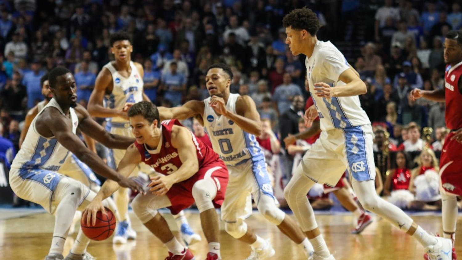 The North Carolina basketball team swarms Arkansas guard Dusty Hannahs (3) leading to a turnover in the second round of the NCAA Tournament in Greenville on Sunday.