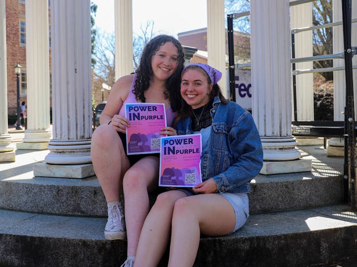 Ellen Garfinkle and Peyton Metzler, the president and treasurer of Cadence a Capella, pose together at the Old Well on Tuesday, Feb. 28, 2023.