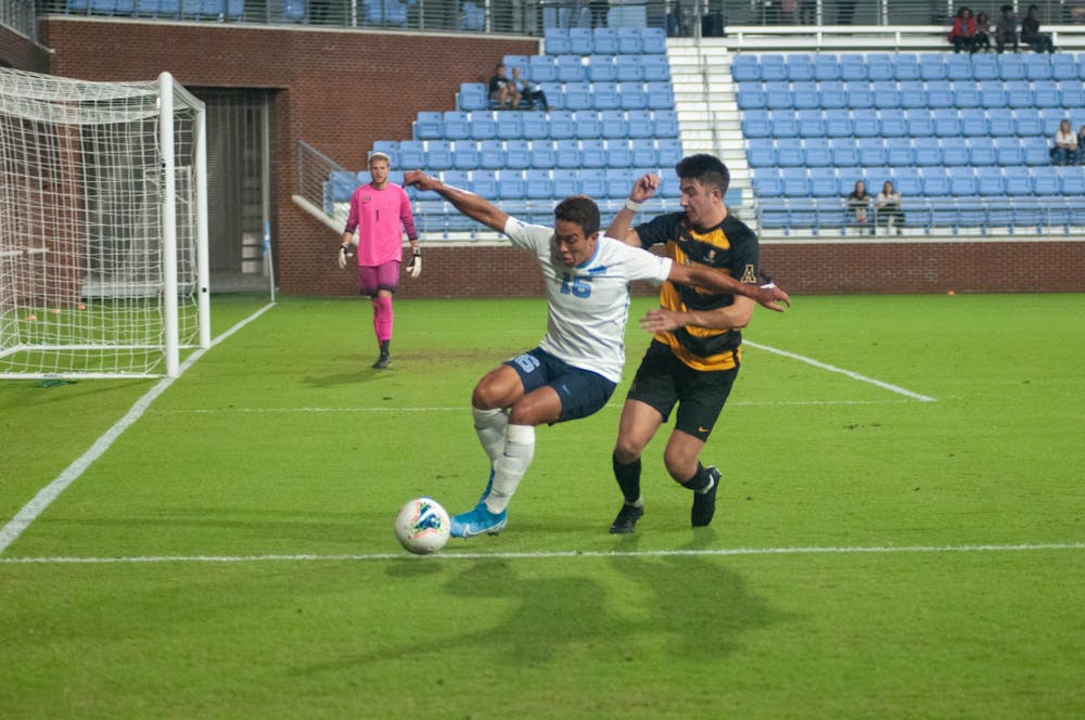 First-year UNC forward Jonathan Jimenez (16) and sophomore Appalachian State University defender Mason Robicheaux (12) chase the ball on Tuesday, Oct. 29, 2019. UNC lost to Appalachian State University 1-0 on a penalty kick.