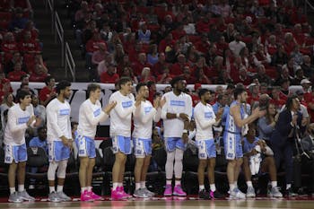 The UNC men's basketball team celebrates after one of their teammates scores a basket during the game against N.C. State in PNC Arena on Monday, Jan. 27, 2020. UNC beat State 75-65.