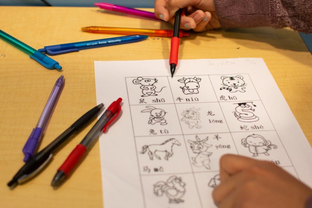 DTH Photo Illustration. A student points at an illustration of a cow accompanied by the Mandarin word on a practice worksheet in Chapel Hill, N.C., on Monday, March 18, 2019. Glenwood Elementary resolved to expand their Mandarin immersion program and phase out other tracks, prompting redistricting for current kindergarteners whose parents did not want them to participate.