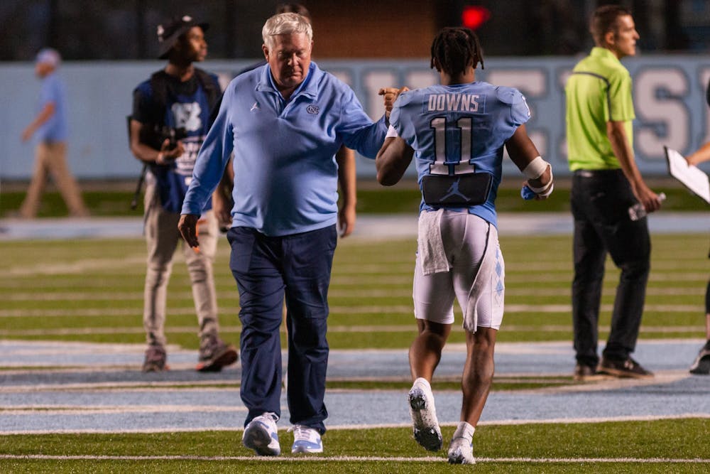 Head coach Mack Brown fist bumps junior wide receiver Josh Downs (11) after a win versus Florida A&M at Kenan Stadium on Aug. 27. The Heels won 56-24.