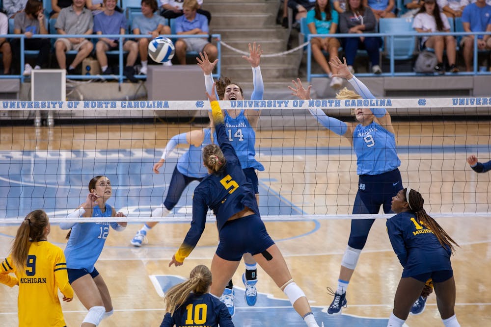UNC junior middle hitter Kaya Merkler (14) and UNC sophomore Mabrey Shaffmaster (9) block the ball during volleyball match against Michigan on Saturday, Sept. 10, 2022, at Carmichael Arena. Michigan beat UNC 3-0.