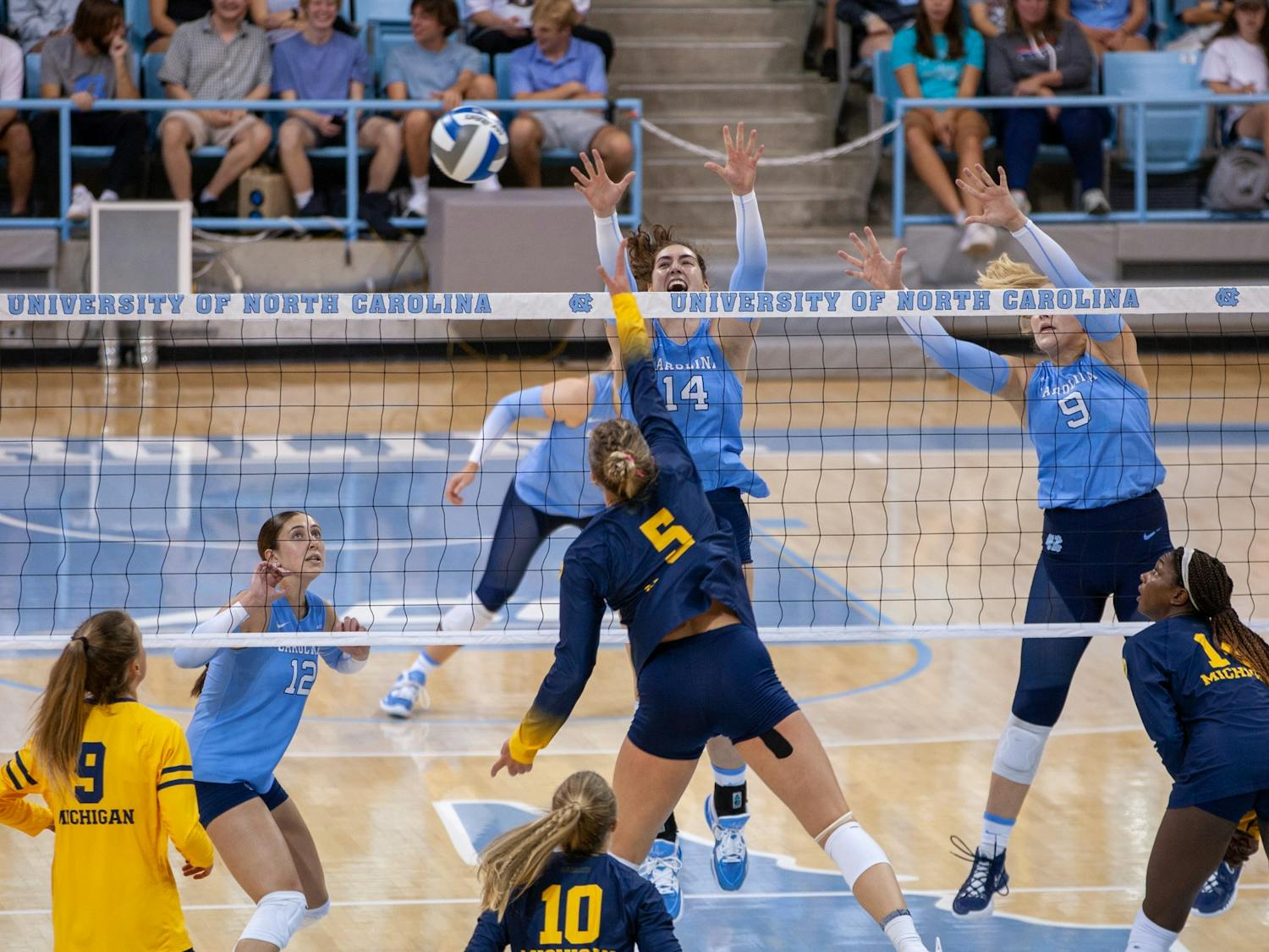 UNC junior middle hitter Kaya Merkler (14) and UNC sophomore Mabrey Shaffmaster (9) block the ball during volleyball match against Michigan on Saturday, Sept. 10, 2022, at Carmichael Arena. Michigan beat UNC 3-0.