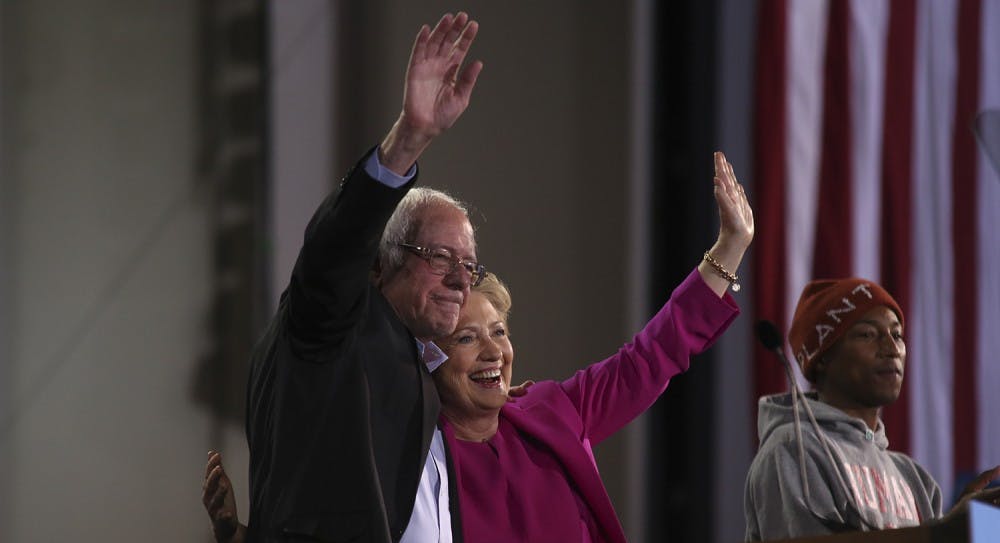 <p>Bernie Sanders (left) and Hillary Clinton wave to the crowd after Pharell Williams’ (right) plea for women's rights.</p>
