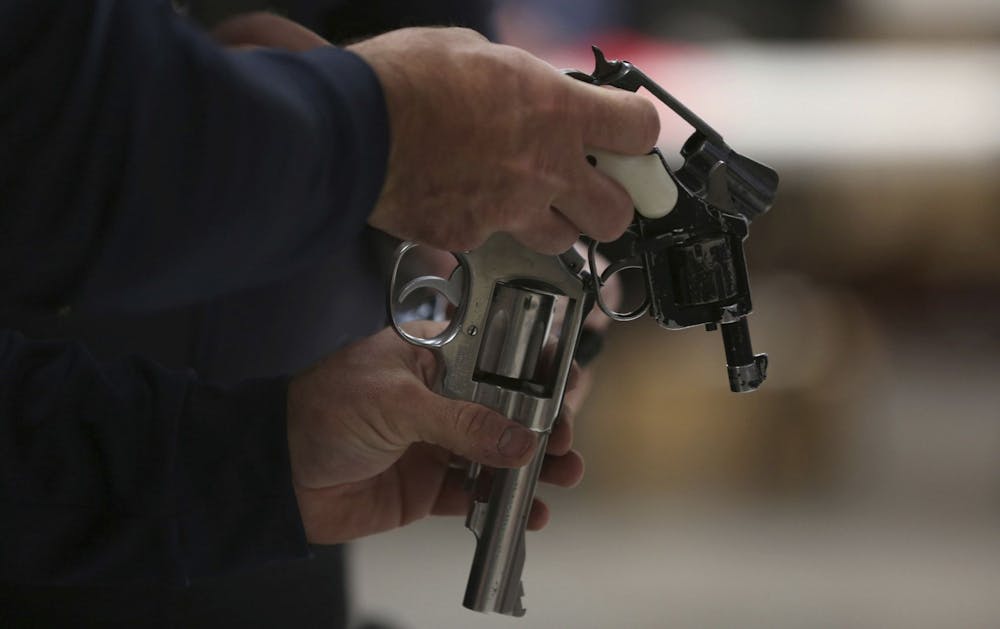 A Chicago police officer inspects guns during a buyback program in 2016. Photo courtesy of TNS.